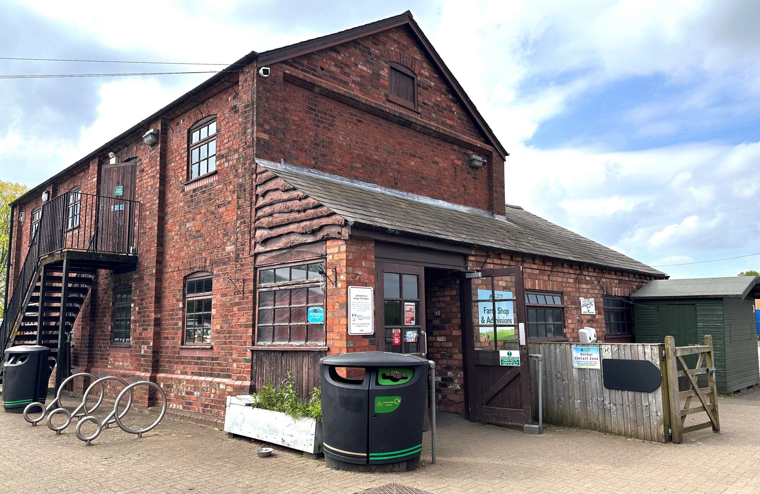 A brick building with a bike rack on the side.